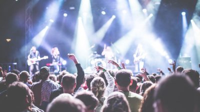 Publikhav tittar mot scenen där artister spelar musik