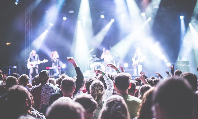 Publikhav tittar mot scenen där artister spelar musik