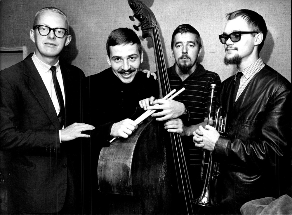 Fyra musiker står på rad med sina instrument. Den andra från vänster är Janne Carlsson.