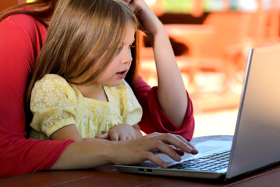 En flicka som tittar på en laptop.