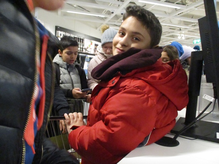 Ett barn i röd jacka tittar in i kameran.