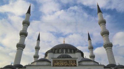 En stor byggnad med flera runda tack. Det sticker upp fyra smala torn ur huset, med varsitt spetsigt tak och balkonger runtom.