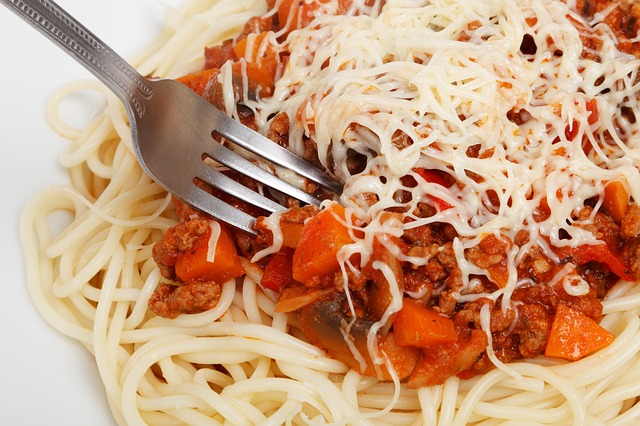 Närbild på pasta med tomatsås och en gaffel.