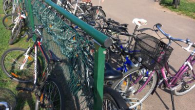 Många cyklar trängs kring ett staket.