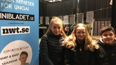 Tre barn vid en MiniBladet-affisch