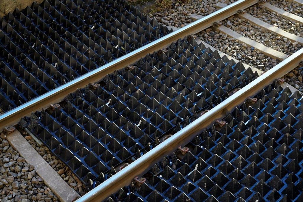 Spetsiga pyramidmattor över ett tågräls