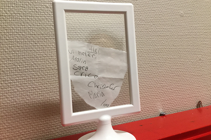 Ett foto på den handskrivna lappen som eleverna hittade. På lappen står det fem namn och årtalet 1998.