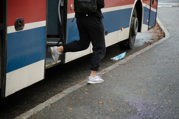 Person som går av en buss.